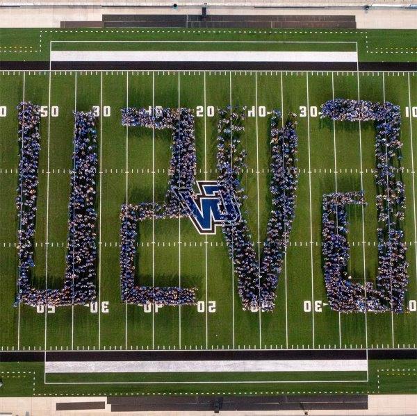 incoming students stand on football field, creating GVSU for a drone photo